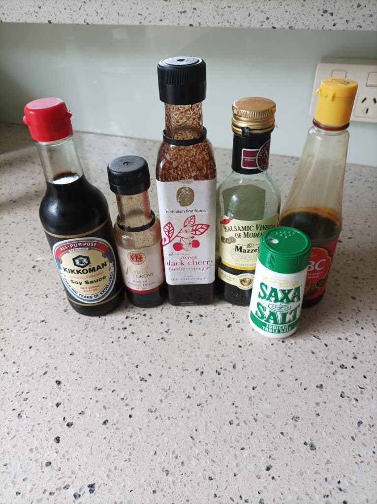 Common condiments in six small bottles illustrating how you needn't forgo flavour to save on space