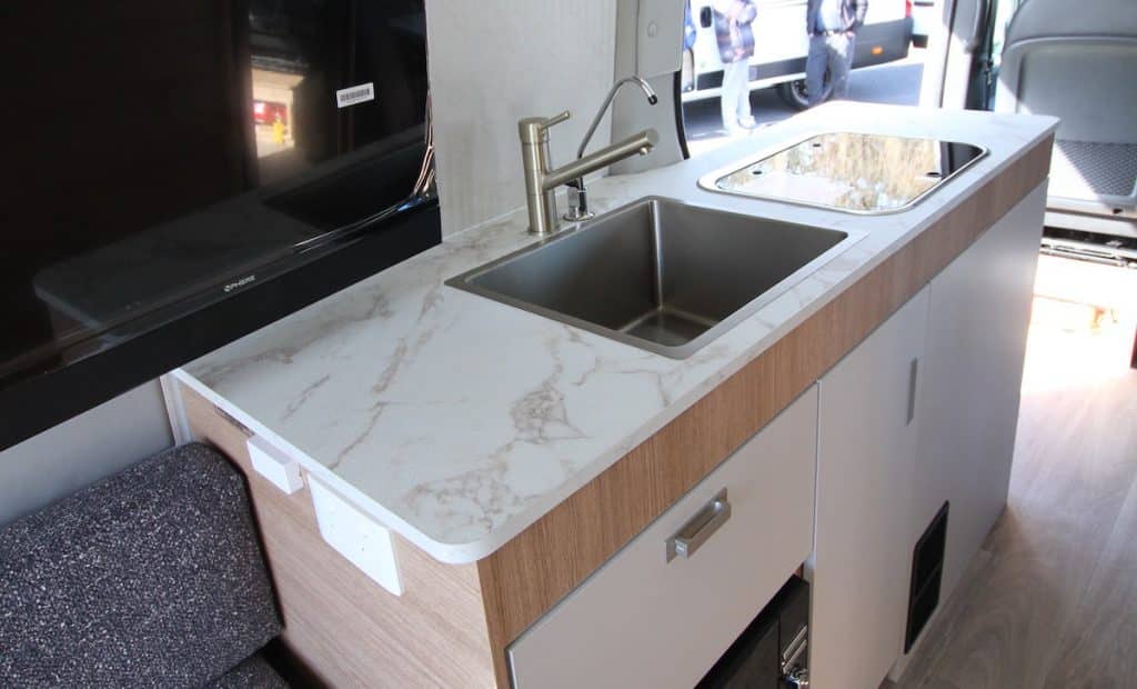 Caravan interior of the Jayco JRV AV showing a marble-like galley benchtop with a deep square matt chrome sink, 