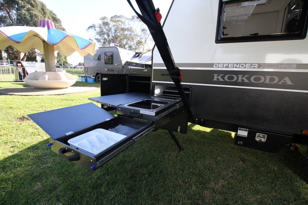External close up of a caravan with a Bushtucker slide-out kitchen. The van is a Kokoda Defender XCORE