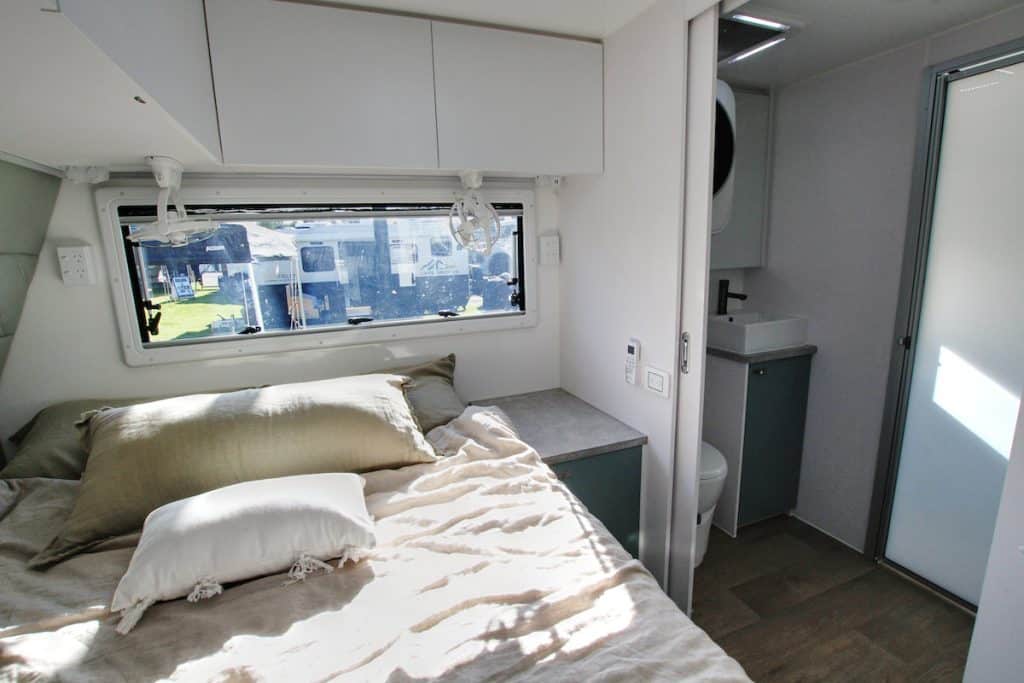 Interior of the Kokoda Defender XCORE showing the bed on right, and a bathroom on the left, accessible via a wider than average sliding door.
