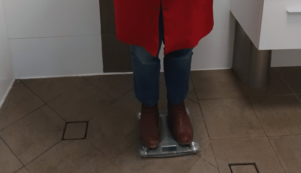 Alison Huth stands on scales fully clothed. Step one to calculating the weight of her clothes